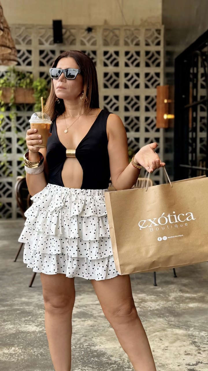 Clienta con body negro y falda de lunares con bolsa de Exotica