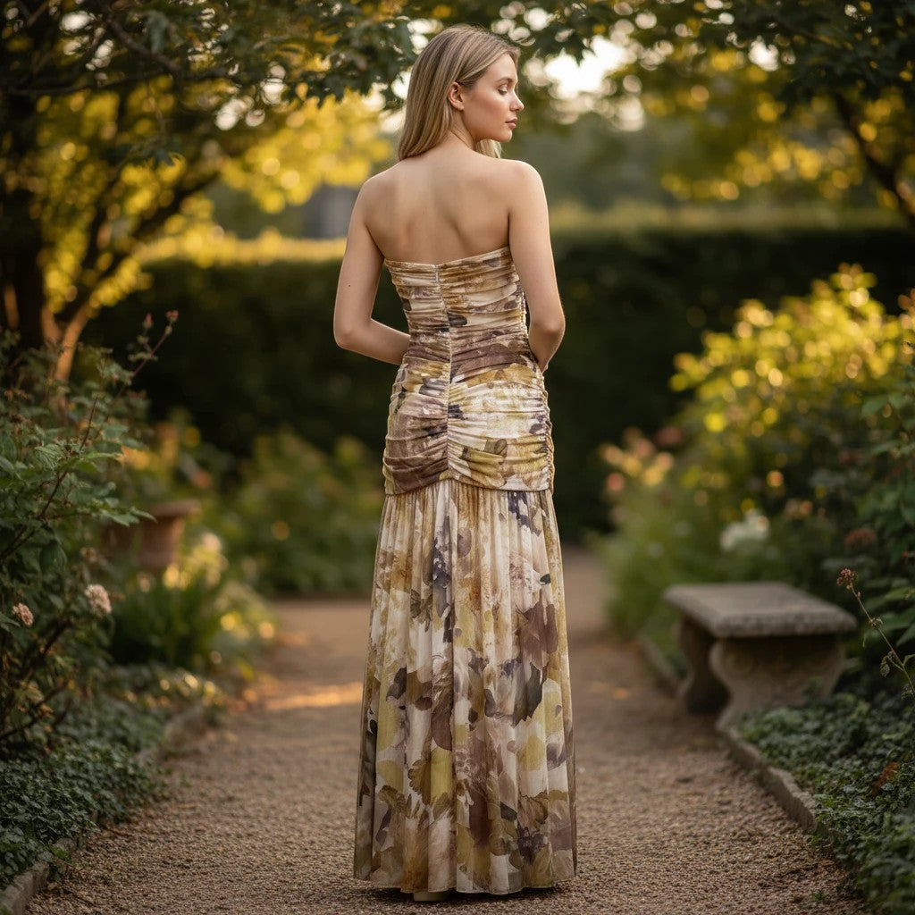 Vestido largo Exotica palabra de honor con estampado floral en tonos tierra y drapeado en un jardín al atardecer